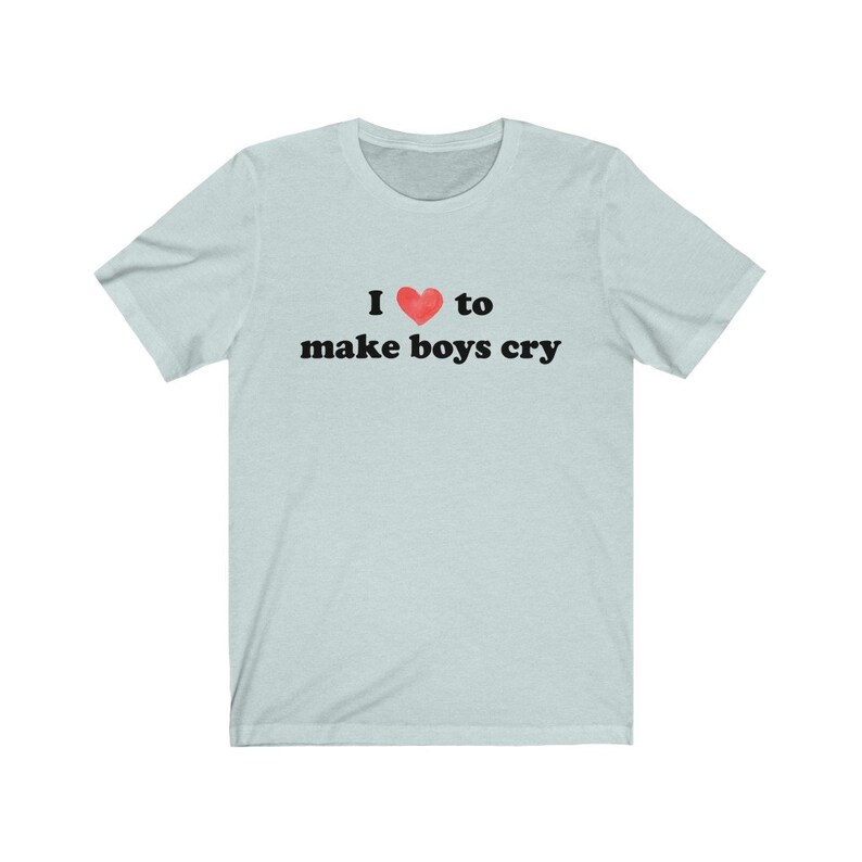 Puede incluir: Camiseta azul claro con la frase "I ❤ to make boys cry" en negro. El s&iacute;mbolo del coraz&oacute;n es rojo. La camiseta tiene mangas cortas y cuello redondo.