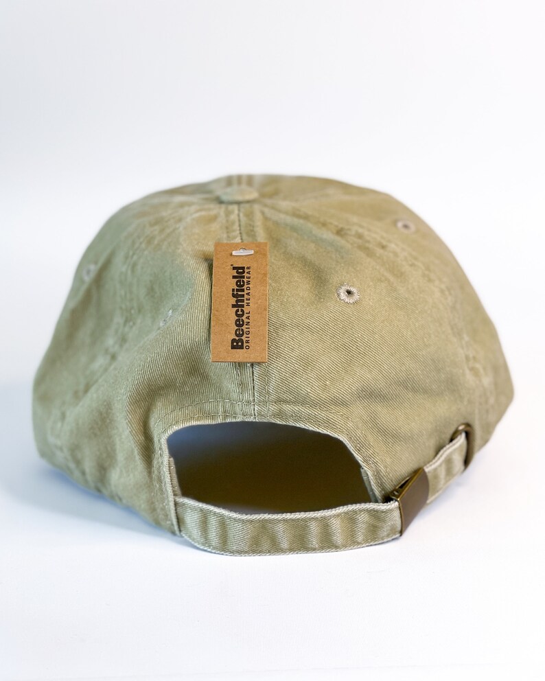 May include: A green baseball cap with a brown tag that says "Beechfield Original Headwear".