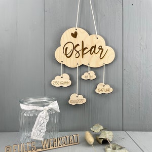 Könnte beinhalten: Ein Schild aus Holz in Wolkenform mit dem Namen "Oskar" und Details zur Geburt des Babys: 2.753 Gramm, 48 cm, 03.01.2022, 15:47 Uhr. Das Schild hängt an einer Schnur und darunter befindet sich ein Holzschild mit dem Text "@eules_werkstatt".