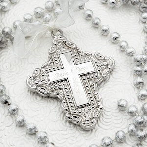 Può includere: Ciondolo a forma di croce in argento con un design elaborato e i nomi Maria & Jorge e l'anno 2024 incisi sul davanti.