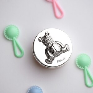 May include: Silver keepsake box with a 3D embossed teddy bear design and the name "Emily" engraved on the front.