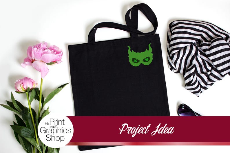 May include: Black tote bag with a green graphic design, a black and white striped scarf, and pink flowers. The tote bag has a green mask design. The text "Project Idea" is on a red banner.