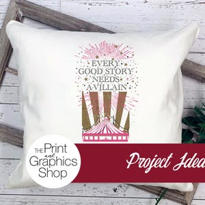 May include: A white square throw pillow featuring a graphic print of a circus tent in pink and gold. Above the tent, the text reads: EVERY GOOD STORY NEEDS A VILLAIN, surrounded by gold stars and pink radiating lines on the fabric surface.
