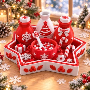 Op de afbeelding: Een stervormig serveerblad in rood en wit met twee rode flessen met sneeuwvlok- en strikaccenten, een witte fles met een boomontwerp, een rode kom gevuld met rode en witte bollen, een klein cadeautje, een zuurstok en een belletje.