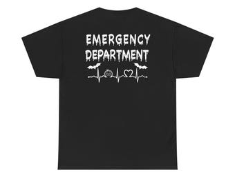 Op de afbeelding: Zwart T-shirt met witte tekst die "Emergency Department" luidt met een druppelend effect. De tekst wordt vergezeld door een hartslaggrafiek met een pompoen en een hart symbool.