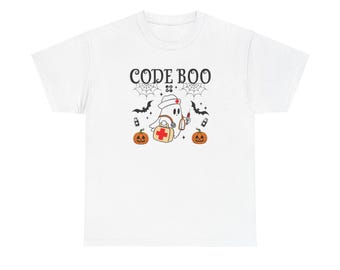 Op de afbeelding: Wit T-shirt met een spook dat een verpleegstersmuts draagt en een medische tas draagt. De tekst "CODE BOO" staat op het shirt, samen met afbeeldingen van vleermuizen en pompoenen.