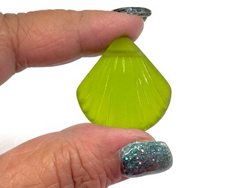 May include: A lime green glass seashell charm with a ribbed texture.