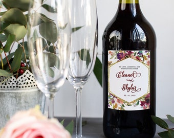 Könnte beinhalten: Eine Weinflasche mit einem personalisierten Etikett mit einem Blumendesign und goldenen Akzenten. Das Etikett lautet "To love, laughter, and happily ever after, Eleanor & Skylar 03.01.2022".