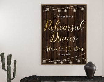 May include: A rustic wooden sign with string lights, announcing a rehearsal dinner for Alexis and Christian on July 29, 2022. The sign features the words "Welcome to our Rehearsal Dinner" in gold lettering.