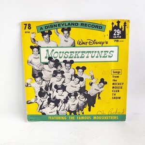 May include: Vintage "Mouseketunes" record album cover. The yellow cover features a group of children wearing Mickey Mouse ears. Text includes "A Disneyland Record" and "Songs from the Mickey Mouse Club TV Show."