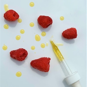 May include: A white dropper bottle with a clear glass dropper and a white cap.  The bottle is surrounded by red raspberries and yellow drops on a white background.