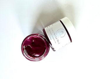 May include: A small glass jar with a white lid containing a deep purple face mask. The jar is labeled "Honey Nectar Mask" with the text "See Products - Enzymes - Hair" and "1.7 fl oz".