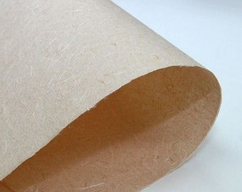 May include: Close-up of a sheet of textured, off-white paper with visible fibres. The paper is folded in half, revealing a lighter, cream-coloured underside.