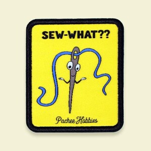 May include: A yellow patch with a black border featuring a cartoon needle with blue thread and the text "SEW-WHAT??". Below the needle is the text "Pachee Hobbies".