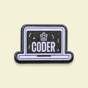 以下が含まれることがあります： 白いブロック文字で「CODER」という言葉が入った、ノートパソコンの形をした刺繍パッチ。ノートパソコンの画面は黒で、白いアクセントがあり、「CODER」という言葉の上にブランド名「PACHEE」があります。パッチには黒い縁取りがあります。