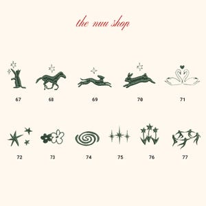 May include: A collection of dark green embroidered designs on a cream background. The designs include a cat, horse, running hare, rabbit, swans, stars, flowers, a spiral, and figures. The text "the nuu shop" is at the top.
