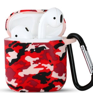 Puede incluir: Funda de silicona con estampado de camuflaje rojo, negro y rosa para auriculares inalámbricos con mosquetón negro.