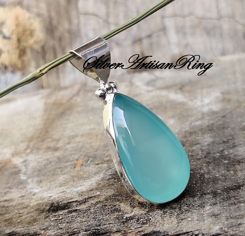 May include: A teardrop-shaped pendant with a light blue chalcedony stone set in sterling silver.