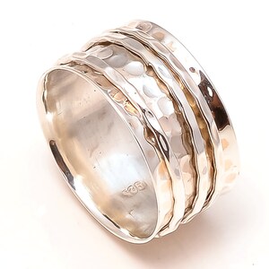 May include: A silver spinning ring with a hammered texture and three bands. The ring is marked with "925" on the inside.