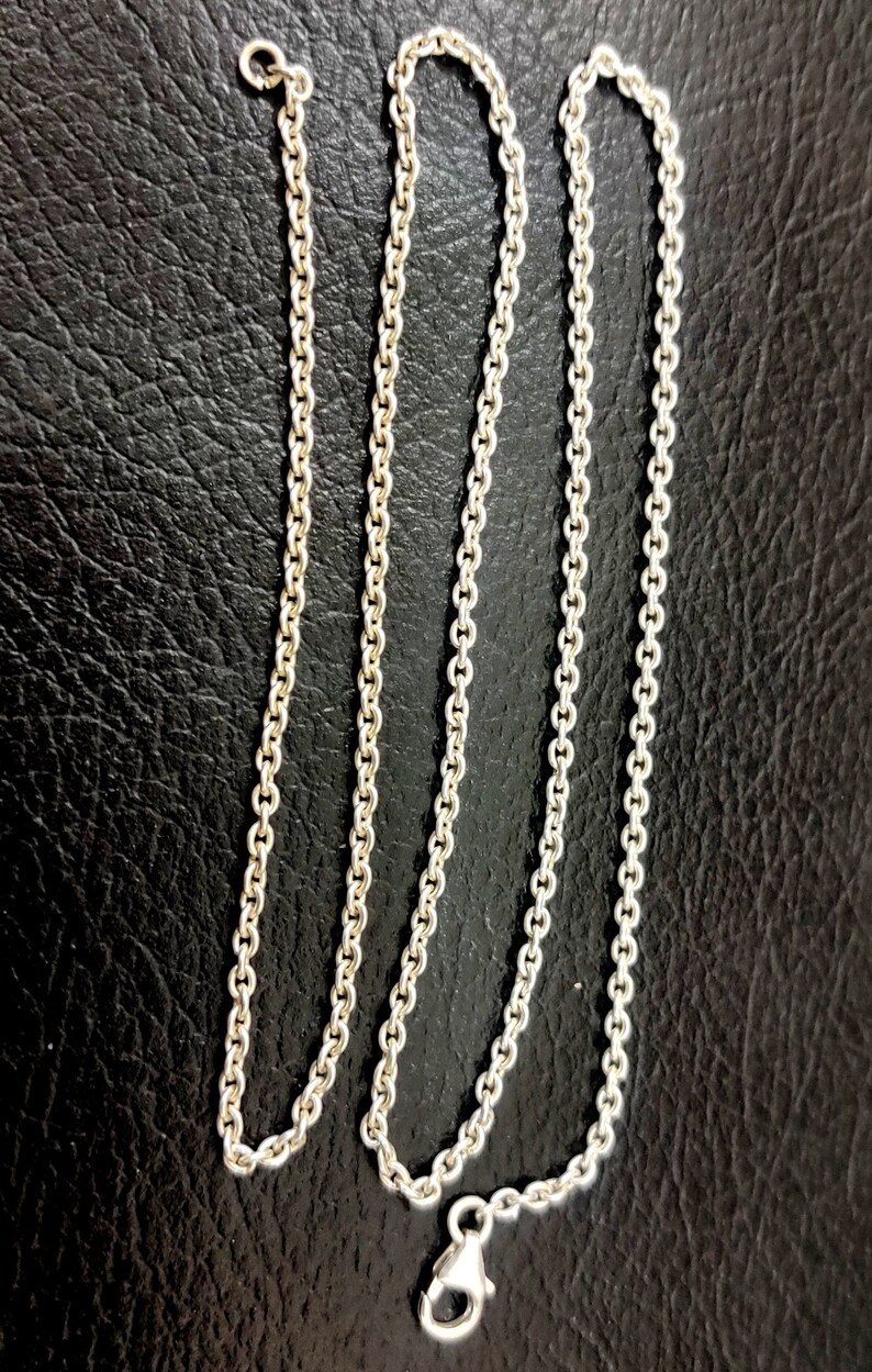 Puede incluir: Un collar de cadena de plata con cierre de mosquet&oacute;n. La cadena est&aacute; hecha de peque&ntilde;os eslabones redondos.