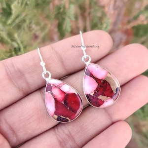 Könnte beinhalten: Ein Paar silberne Ohrhänger mit tropfenförmigen roten, rosa und goldenen Jaspis-Steinen.