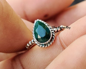 Puede incluir: Un anillo de piedra preciosa verde en forma de pera engastado en plata de ley con una banda trenzada.