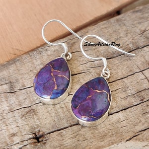 Pu&ograve; includere: Un paio di orecchini in argento sterling con pietre di turchese viola e rame a forma di lacrima. Gli orecchini hanno una chiusura a gancio semplice.
