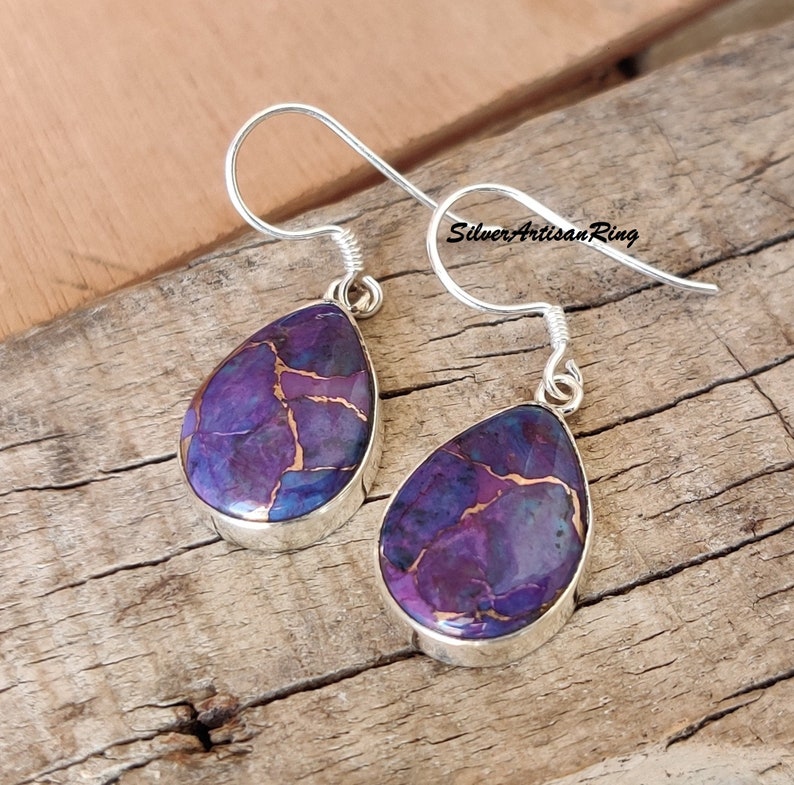 Pu&ograve; includere: Un paio di orecchini in argento sterling con pietre di turchese viola e rame a forma di lacrima. Gli orecchini hanno una chiusura a gancio semplice.