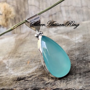 May include: A teardrop-shaped pendant with a light blue chalcedony stone set in sterling silver.