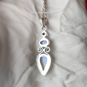 May include: Silver pendant with a teardrop-shaped moonstone and a smaller oval moonstone. The pendant has a detailed design with swirls and the number 925 stamped on the back.
