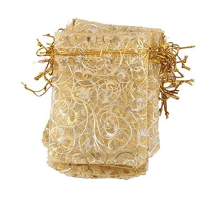 May include: A stack of gold organza gift bags with a white swirl pattern and gold drawstring closures.