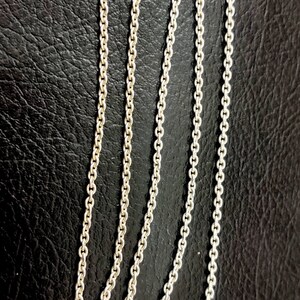 Puede incluir: Un collar de cadena de plata con cierre de langosta.