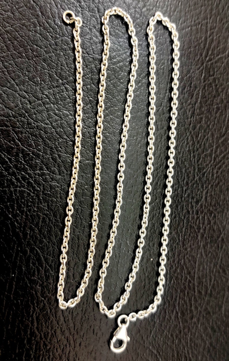 Puede incluir: Un collar de cadena de plata con cierre de langosta.