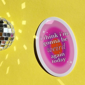May include: A pink and purple oval sticker with a white outline. The sticker has a rainbow gradient background with the text "i think i'm gonna be weird again today" in white.