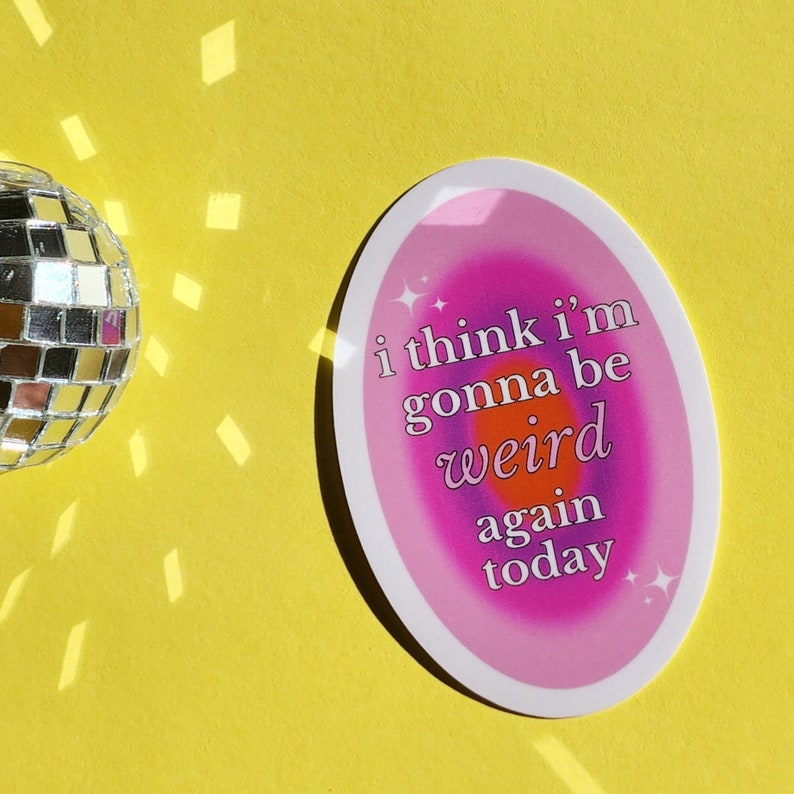 May include: A pink and purple oval sticker with a white outline. The sticker has a rainbow gradient background with the text "i think i'm gonna be weird again today" in white.
