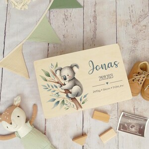 May include: A wooden keepsake box with a koala illustration and the name Jonas, birthdate 29.09.2023, weight 2470g, length 54cm, and time 17:04.
