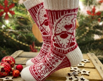 May include: A pair of white and red knitted socks with a Christmas-themed design. The socks feature a white snowflake pattern and a red Santa Claus face.