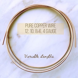 May include: A close-up of a coil of copper wire in various gauges, including 12, 10, 8, 6, and 4 gauge. The wire is on a white marble surface. The text "PURE COPPER WIRE 12, 10, 8, 6, 4 GAUGE Variable Lengths" is visible in the image.
