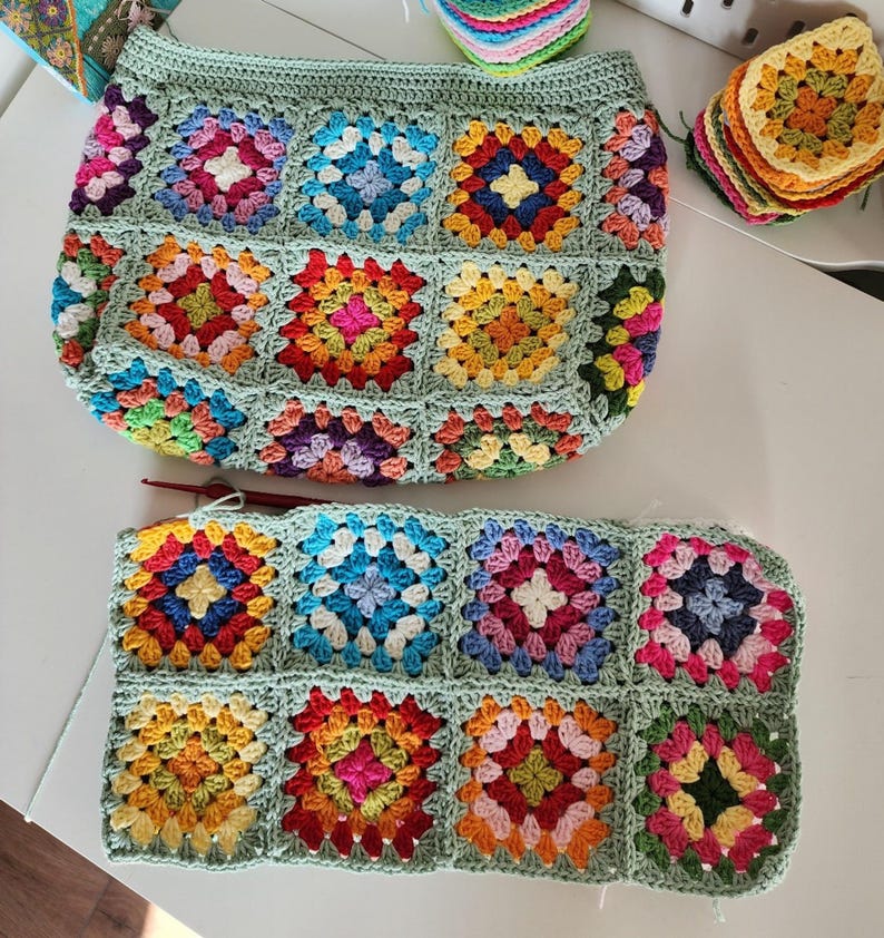 Crochet zipper pouch bag with bright granny-square blocks and mint edging; colorful crochet purse pattern sample.