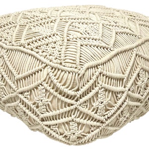 May include: A cream-colored, round, macrame pouf with a geometric pattern. The pouf is made of thick, knotted rope.