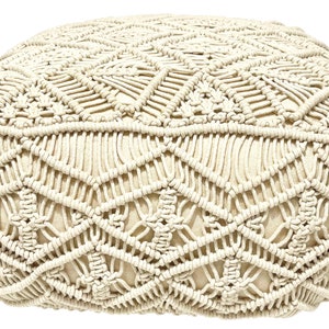 May include: A cream-colored round ottoman with a woven macrame design. The ottoman is made of cotton rope and has a soft, comfortable texture.