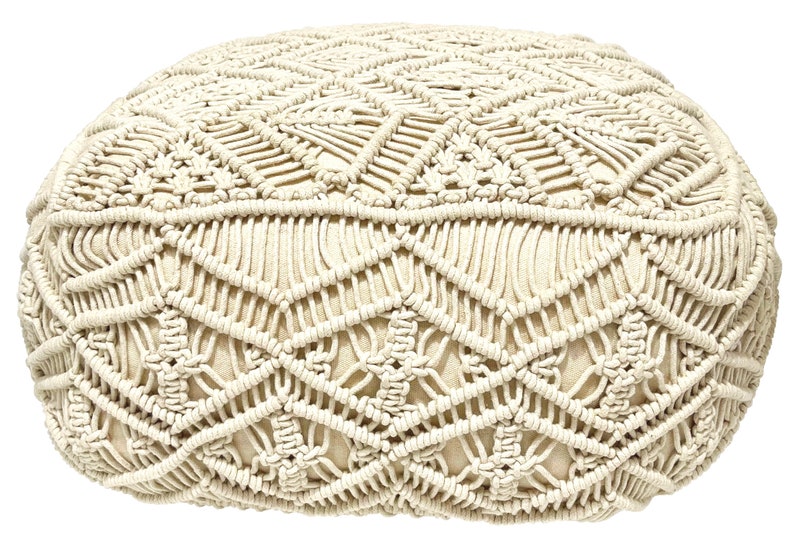 May include: A cream-colored round ottoman with a woven macrame design. The ottoman is made of cotton rope and has a soft, comfortable texture.