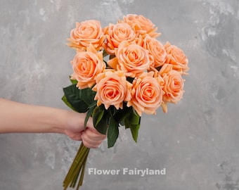 ガラスの花瓶に入ったピーチオレンジのバラの造花アレンジメント