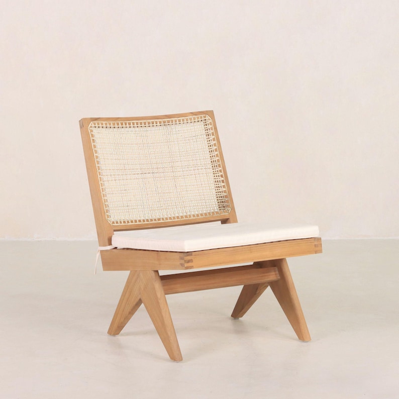 May include: A wooden chair with a woven cane back and a white cushion. The chair has a simple, modern design with angled legs.