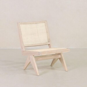 May include: A light wood chair with a woven cane seat and back. The chair has a simple, modern design with angled legs.