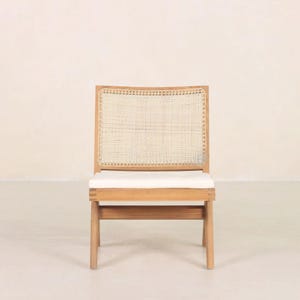 May include: A wooden chair with a woven cane back and a white cushion. The chair has a simple, modern design.