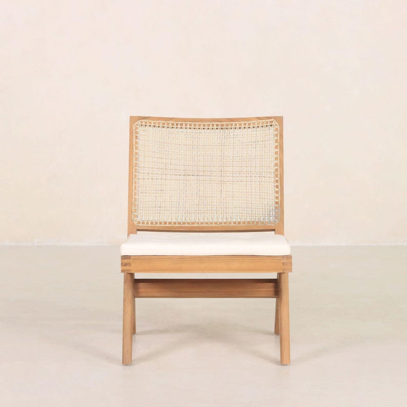 May include: A wooden chair with a woven cane back and a white cushion. The chair has a simple, modern design.