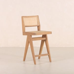 May include: A wooden bar stool with a woven cane seat and back. The stool has a natural wood finish and a simple, modern design.