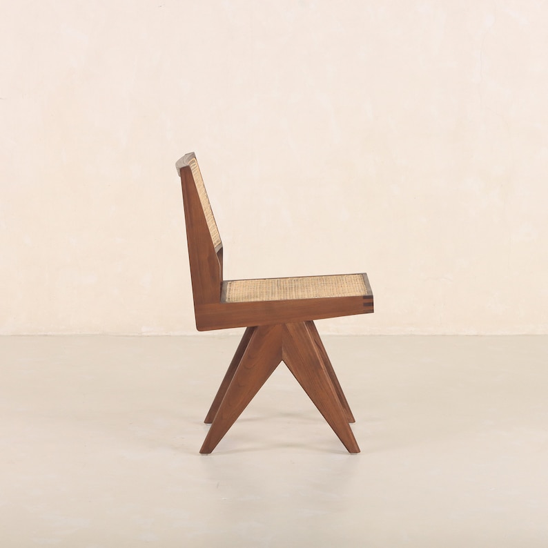 Pode incluir: Uma cadeira de madeira com assento e encosto de vime tecido. A cadeira tem um design &uacute;nico e angulado com quatro pernas.