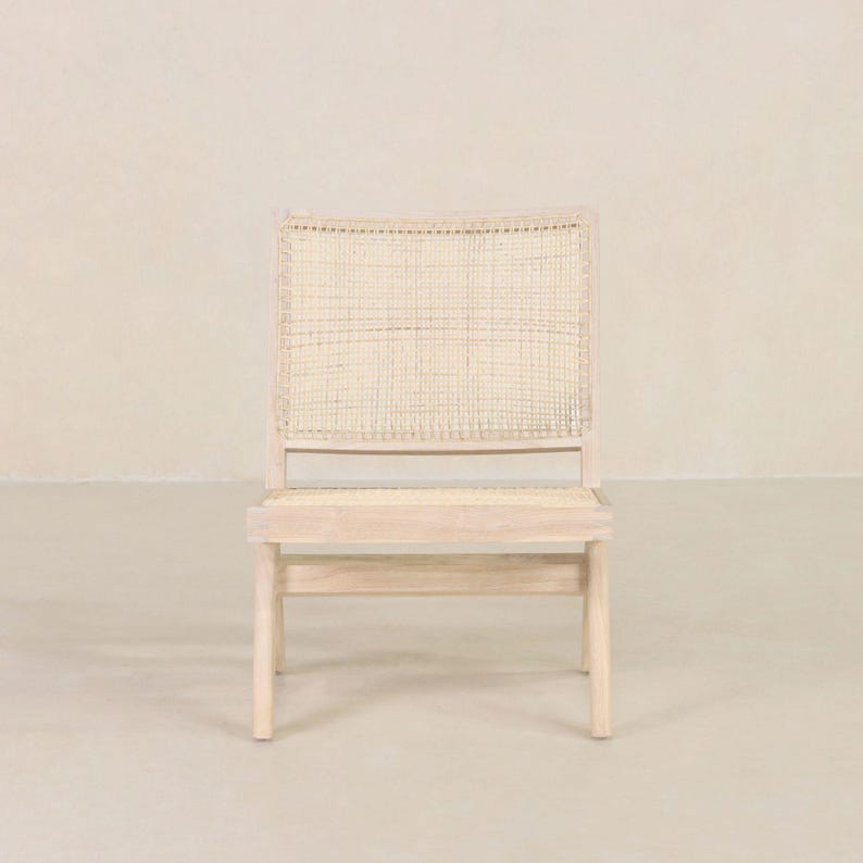 May include: A white wooden chair with a woven cane seat and back. The chair has a simple, modern design.